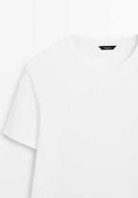 T-shirt blanc à manches courtes avec col rond et une étiquette de marque noire à l'intérieur du col.