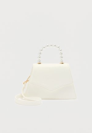 Hvid trapezformet håndtaske med perlebesat hank og aftagelig skulderrem, vist mod en ensfarvet lys baggrund.