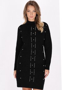Abito in maglia nera con maniche lunghe, collo alto e una fila centrale verticale di perline decorative bianche. Tessuto testurizzato con una forma aderente.