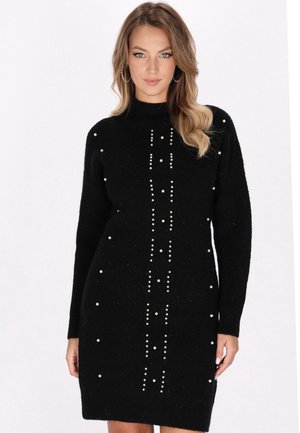 Schwarzes Strickkleid mit langen Ärmeln, hohem Kragen und einer zentralen vertikalen Reihe von weißen dekorativen Perlen. Strukturierter Stoff mit taillierter Form.