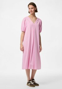 Ružičasta karirana midi haljina s V-izrezom, napučenim kratkim rukavima i naborima. Nošena s smeškim patikama. Glatka tekstura tkanine.