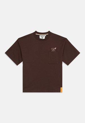 T-shirt marron foncé à manches courtes avec une poche poitrine, au-dessus du bord supérieur de laquelle apparaît un petit ours en peluche.