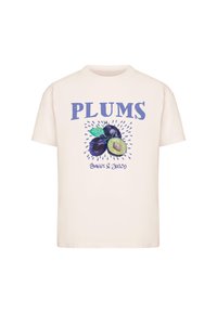 Kreminė medvilninė marškinė su grafine plukų dizaino iliustracija ir mėlynu tekstu "PLUNKS" bei "Saldus ir sultingas." Trumpomis rankovėmis, apvaliu kaklu.