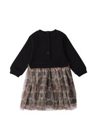 Top de manga larga negro con un cierre de botones en la parte posterior, combinado con una falda de tul en capas que presenta un delicado patrón floral en tonos de marrón.