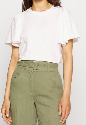 Wit kort mouwtopje met geruffelde mouwen, gecombineerd met olijfgroene broek met riem, gemaakt van een gestructureerde stof en voorzien van zijzakken.