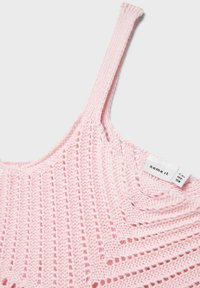 Top sin mangas de punto rosa con un patrón texturizado, tirantes finos y una etiqueta con información de tallas en el lado interior.