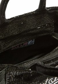 Borsa nera con paillettes, texture in tessuto, chiusura con zip e manici robusti. Interno con fodera morbida e etichetta del marchio.