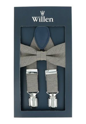 Graue Stofflatzhosen mit silbernen Metallclips, ergänzt durch eine passende Fliege und marineblaue Lederakzente, präsentiert in einer dunkelblauen Box.
