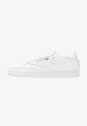 Zapatilla Reebok blanca de perfil bajo con cordones en la parte delantera, panel lateral con marca y suela texturizada sobre fondo blanco.