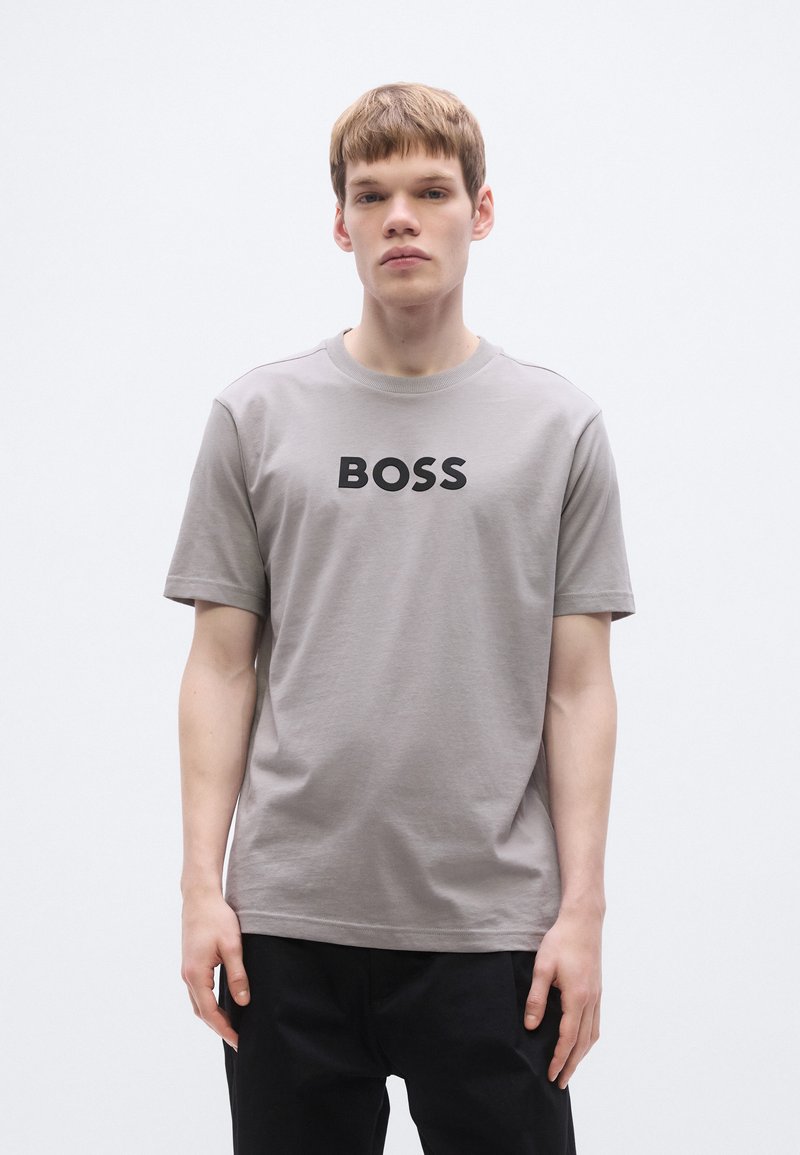 Γκρι βαμβακερό t-shirt με κοντά μανίκια, διαθέτει τολμηρό μαύρο λογότυπο "BOSS" στο μπροστινό μέρος, στρογγυλή λαιμόκοψη και άνετη εφαρμογή.