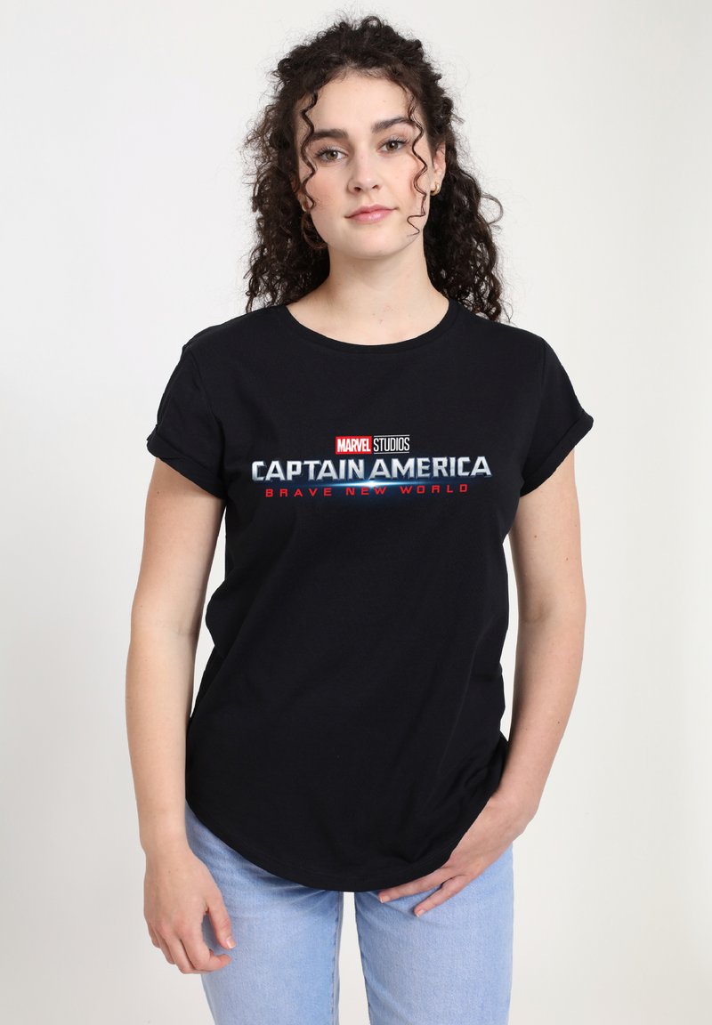 Camiseta de algodón negra con un gráfico de texto "Capitán América: Un Nuevo Mundo". Manga corta, cuello redondo, ajuste relajado. Jeans de mezclilla azul claro.