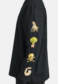 Black long-sleeve shirt with colorful embroidered designs of a horse, broccoli, skull, and shrimp on the left sleeve. Soft cotton material.