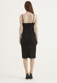 Czarna dopasowana sukienka na cienkich regulowanych ramiączkach, do kolan, z ukrytym zamkiem z tyłu. Gładka tekstura i dopasowany krój.