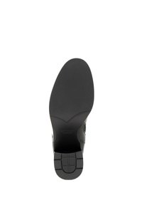 Czarna skórzana podeszwa buta z teksturowanym, wzorzystym uchwytem, oznakowana "WITTCHEN handmade." Charakteryzuje się gładkim, zaokrąglonym kształtem.