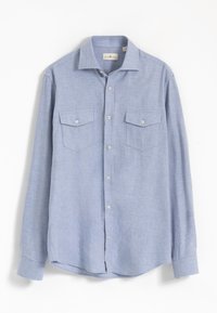 Camisa de manga larga azul claro hecha de tela texturizada. Cuenta con cierre de botones al frente, dos bolsillos en el pecho con solapa y dobladillo redondeado.