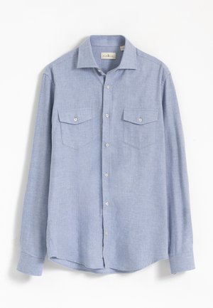 Camisa de manga larga azul claro hecha de tela texturizada. Cuenta con cierre de botones al frente, dos bolsillos en el pecho con solapa y dobladillo redondeado.