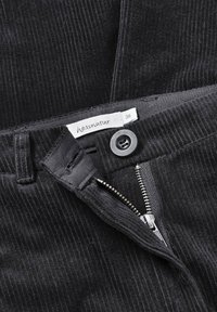 Svarta kordbyxor har en dragkedja och en knappstängning. Midjan har en etikett som visar "hessnatur" med storlek 36.