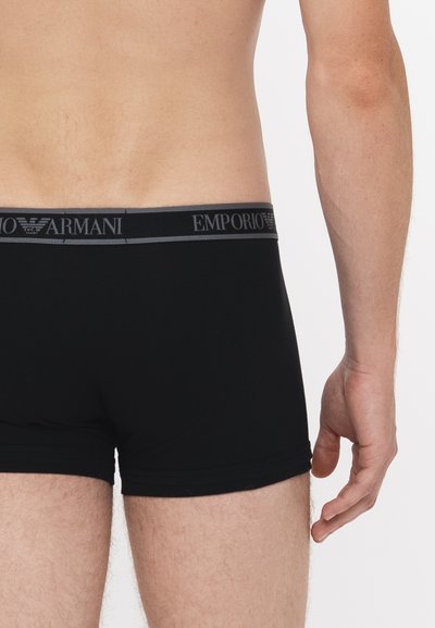 Schwarze Baumwoll-Boxershorts mit einem grauen Emporio Armani-Bund, die eine enge Passform und eine glatte Textur ohne sichtbare Muster bieten.