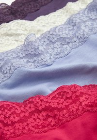 Stof met kantaccenten in paars, wit, lichtblauw en rood, gerangschikt in lagen en voorzien van ingewikkelde bloemenpatronen en zachte texturen.