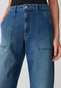 Lichtblauwe denim broek met een wijd uitgesneden ontwerp. Heeft twee voorkruiken, een knoopsluiting en een vervaagde textuur voor een casual uitstraling.