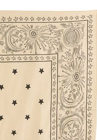 Tela color crema con diseños celestiales delineados en negro que incluyen estrellas, lunas y soles. Borde decorativo con patrones intrincados en todo el tejido.