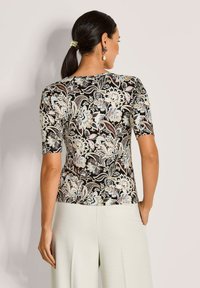 Korte mouwen top in zwart met een bloemen- en paisleymotief in beige, blauw en roesttinten. Gladde stof en aansluitend ontwerp.