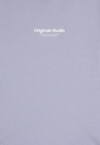 Šviesiai violetinė marškinėliai, pagaminti iš minkštos medvilnės. Su balta spauda, kurioje užrašyta "Originals Studio" ir subtili tekstūra. Paprastas dizainas, apvalus kaklas.