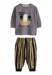 Lila Langarmshirt mit grafischem Gesicht und Text; kombiniert mit leichten, schwarz-beigen gestreiften Hosen mit elastischem Bund und Bündchen.