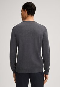 Pull gris à manches longues avec un col rond, une texture lisse, des poignets et un ourlet côtelés, présenté de dos sur un mannequin debout.