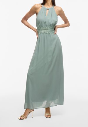 Maxiklædning i blødt grønt stof med halterneck og nøglehulldetalje. Har blondekant i taljen, flydende design og glat overflade.