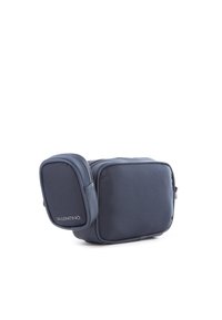 Borsa a tracolla in nylon blu navy con un compartimento principale e una tasca laterale più piccola, dotata di zip e logo impresso. Forma rettangolare.