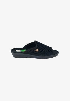 Pantufla negra abierta en la parte delantera, tipo slip-on, con parte superior de malla transpirable y suela baja con cuña, que presenta un pequeño emblema dorado en el lateral.