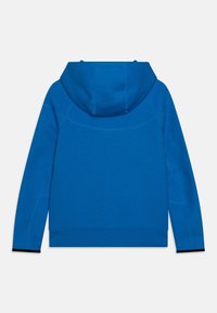 Blå luvtröja med slät textur, utrustad med en rundad huva, långa ärmar och kontrasterande svarta detaljer vid muddarna.