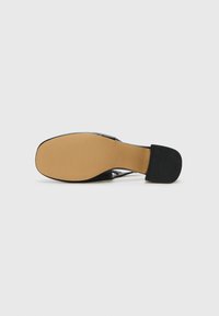 Black high-heeled shoe with a closed toe, glossy material, and contrasting tan rubber sole. Features a textured heel for grip and stability.