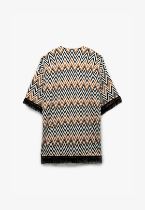 Franje kimono in patroon geweven stof met een zigzagdesign in zwart, wit en roest-oranje. Korte mouwen en open voorkant.