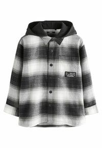 Chemise à carreaux noir et blanc avec capuche, présentant une poche, une fermeture à boutons et un tissu texturé à motif à carreaux.