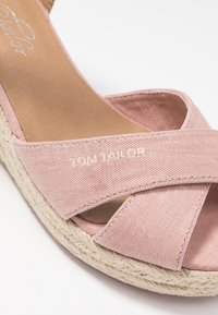 Růžové plátěné espadrilky se zkříženými popruhy, s juty obalenou podrážkou a bílým vyšíváním značky "Tom Tailor". Plochý vnitřek.