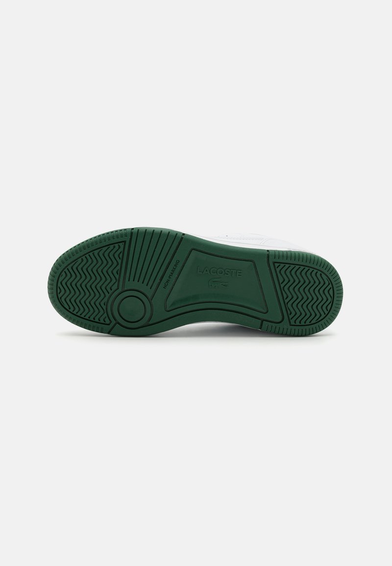 Witte sneaker met een groene rubberen buitenzool, voorzien van een patroon in de tread en een reliëf logo van het merk. Bovenmateriaal lijkt soepel en duurzaam.