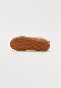 Semelle de sneaker, matériau en caoutchouc, couleur orange, motif de grip texturé avec des formes de diamants et vue partielle sur la section supérieure.