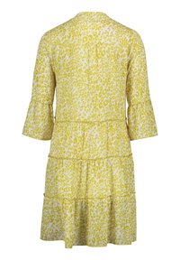 Żółta sukienka w leopardzi deseń z trzema ćwiartkami rękawów w formie dzwonu, warstwowymi falbanami i okrągłym dekoltem. Miękka tkanina, lekki design.