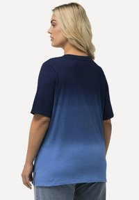 T-shirt med kort ärm i en gradient från mörk marinblå till ljusblå, tillverkad av mjukt tyg; har rundad hals och sidofickor.