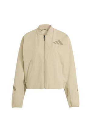 Chaqueta beige recortada con cierre de cremallera, cuello de canalé y puños elásticos. Presenta un discreto logo estampado y dos bolsillos frontales. Textura suave.