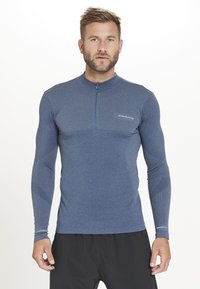 Langærmet, blå atletisk skjorte med halv-lynlås krave, struktureret mønster på overkroppen og ærmerne, tætsiddende design, velegnet til sport.