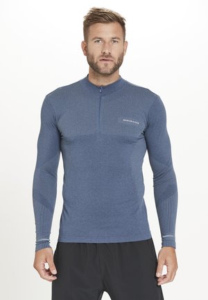 T-shirt de sport bleu à manches longues avec un col zippé mi-haut, motif texturé sur le haut du corps et les manches, design ajusté, convient pour les activités sportives.