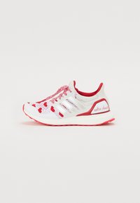 Bijela trkačka cipela s crvenim akcentima, mrežastim gornjim dijelom, teksturiranim vezicama i podstavljenim potplatom. Ima tri bijele pruge i "ultra boost" na peti.