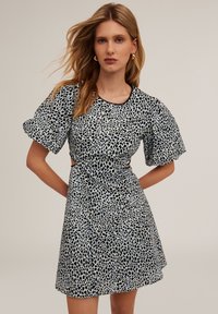 Musta ja vaaleansininen pilkullinen mekko, jossa on puffihihat, leikatut sivut, pyöreä kaula-aukko ja istuva siluetti, valmistettu sileästä kankaasta.