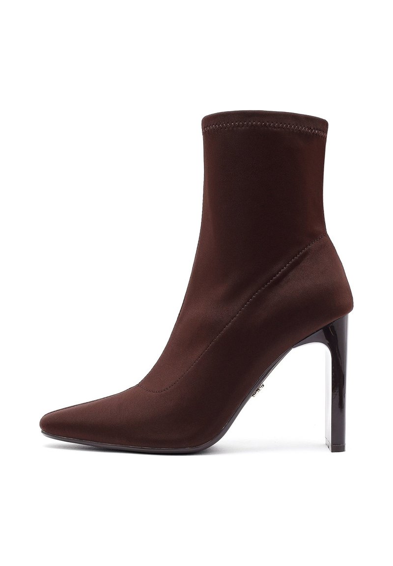 Bottine en tissu marron avec une silhouette ajustée, un bout pointu et un talon haut et brillant. Des coutures ajoutent de la structure au design.