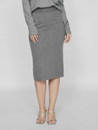 Jupe midi en tricot gris au design ajusté, avec une taille côtelée et une finition d'ourlet subtile. Portée avec des talons ouverts argentés.