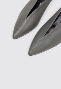 Gray leather pointed-toe shoes with an open slit design. Smooth texture and minimalistic accents enhance the modern look.