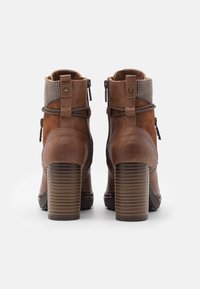 Bruine leren enkellaarsjes met een gestructureerde afwerking, geribbelde hoge hak en decoratieve grijze accenten bij de kraag en de zijritsen.